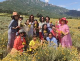 Isabelle dans un champs d'immortelles avec ses clients japonais en Corse